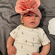 Emery Rose is registered to the contest to win money with this photo: adorable, baby, blanket, child, clothing, cute, eyes, face, flower_pattern, hands, headwrap, indoor, infant, lying_down, newborn, onesie, pink, portrait, skin, soft_texture