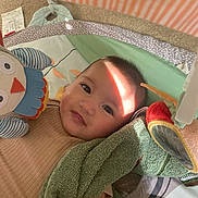 Emery Rose is registered to the contest to win money with this photo: baby, infant, child, playmat, toy, plush_owl, towel, smile, face, head, cute, indoor, soft_toys, carpet, light, sunbeam, blanket, clothing, person, baby_gym