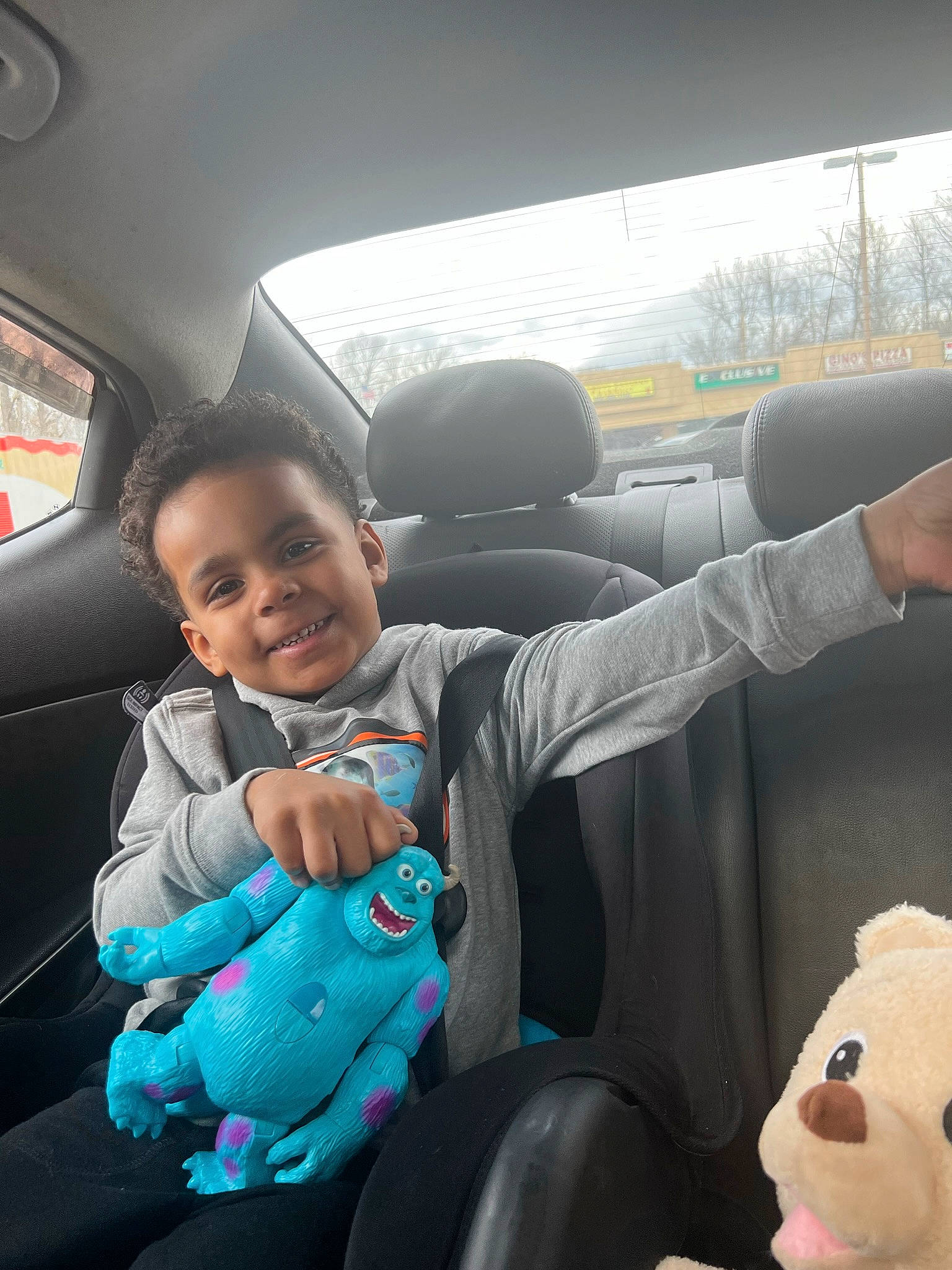 Macklin is registered to the contest to win money with this photo: auto_part, automotive_design, automotive_exterior, car, car_seat, car_seat_cover, comfort, finger, gesture, head_restraint, joy, motor_vehicle, person, smile, steering_part, steering_wheel, toddler, travel, vehicle, vehicle_door