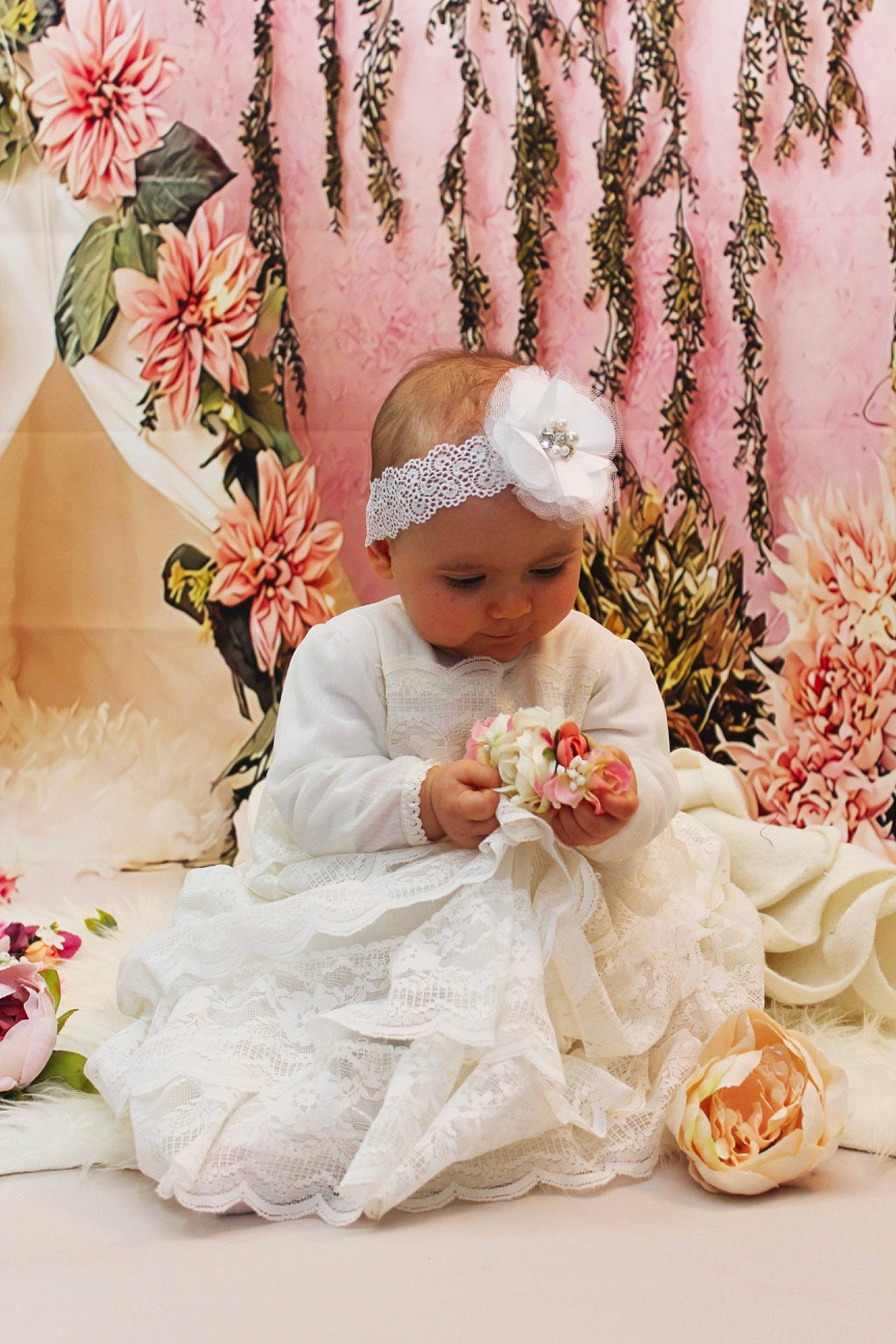 Héloïse participe au concours pour gagner de l'argent avec cette photo : baby, baby_toddler_clothing, bridal_accessory, child, cut_flowers, dress, embellishment, flower, hair_accessory, happy, headgear, headpiece, headwear, linens, peach, person, petal, photograph, pink, plant