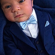 Nathan Pache joined the competition — help win amazing prizes! baby, infant, newborn, face, bow_tie, suit, jacket, vest, pocket_square, formal_wear, portrait, close_up, blue, dark_blue, eyes, cheeks, skin, button, fabric, lying_down