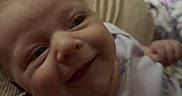 Paisley is registered to the contest to win money with this photo: baby, child, closeup, clothing, comfort, cushion, cute, eyes, face, floral, happy, indoors, infant, newborn, person, portrait, purple, relaxing, skin, smile