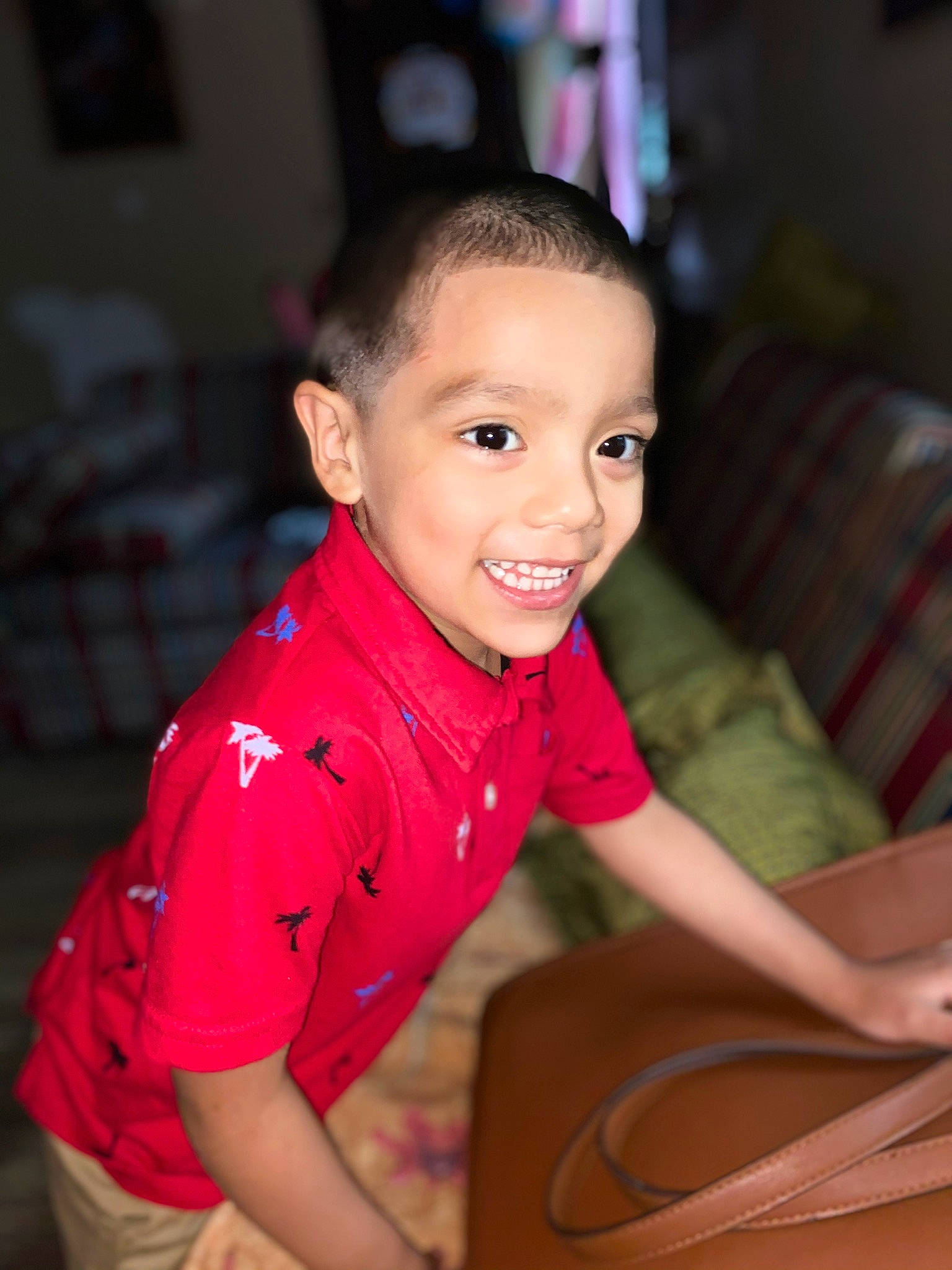 Daniel is registered to the contest to win money with this photo: audio_equipment, carmine, chair, cheek, child, flash_photography, flooring, fun, gadget, happy, joy, leisure, person, recreation, sitting, skin, smile, t_shirt, table, tartan