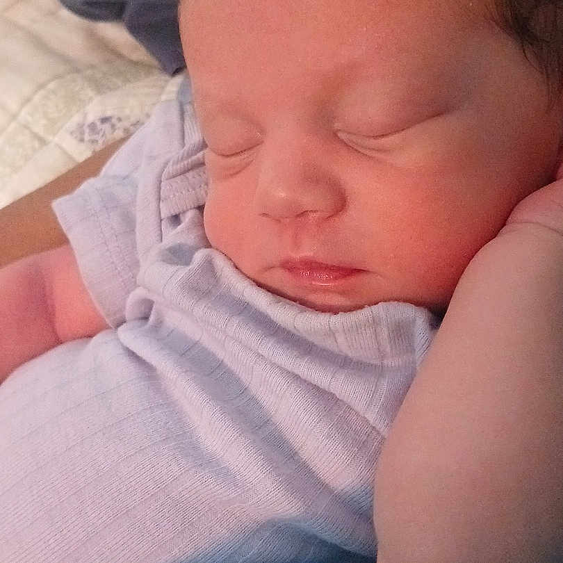 Arabella is registered to the contest to win money with this photo: newborn, baby, infant, sleeping, sleepy, portrait, face, eyes_closed, resting, swaddled, clothing, lavender, adult_arm, holding, closeup, indoors, soft_lighting, peaceful, blanket, family