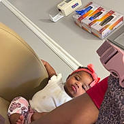 Lani joined the competition — help win amazing prizes! baby, child, headband, pink, chair, indoor, person, wall, boxes, adult, patterned_clothing, sitting, looking, furniture, relaxed, calm, human, casual, closeup, portrait