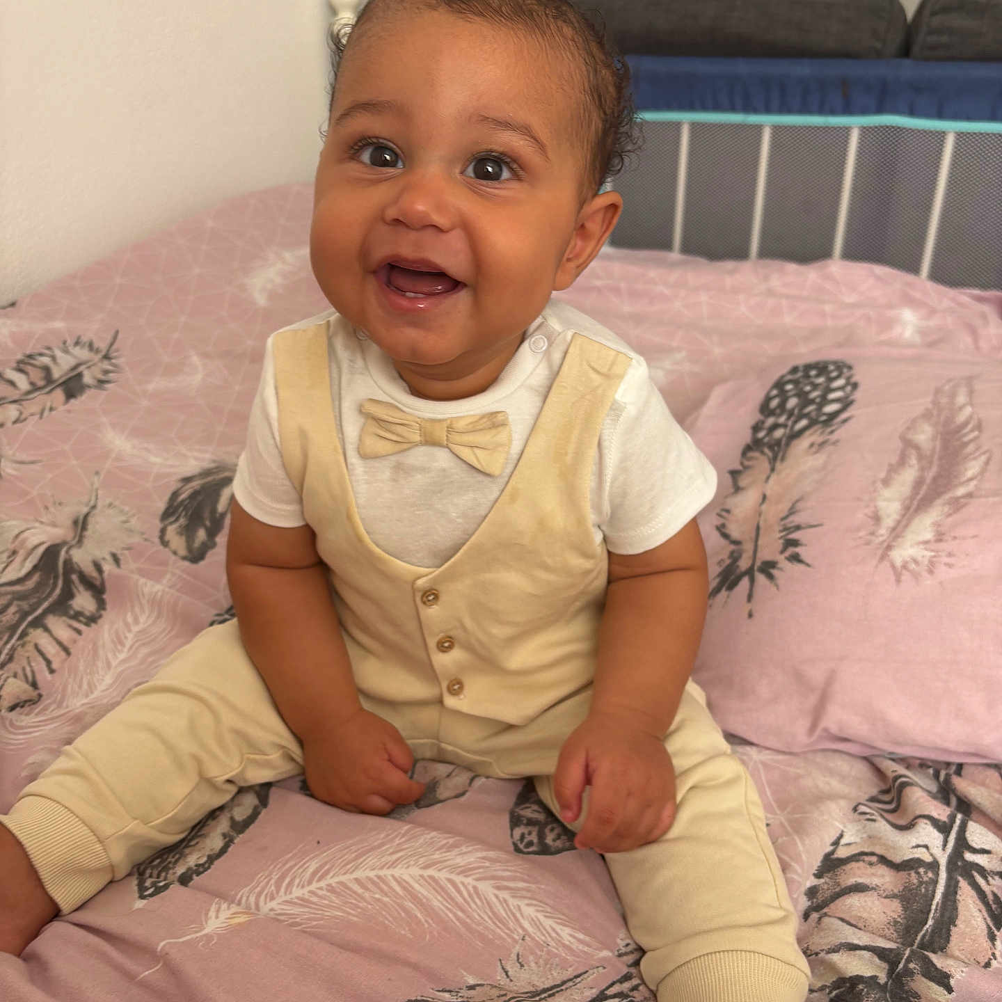 Saint Given joined the competition — help win amazing prizes! baby, bed, blanket, bow_tie, child, clothing, cream_outfit, cute, feather_pattern, furniture, happy, home, indoors, infant, person, pink, portrait, sitting, smiling, young_child