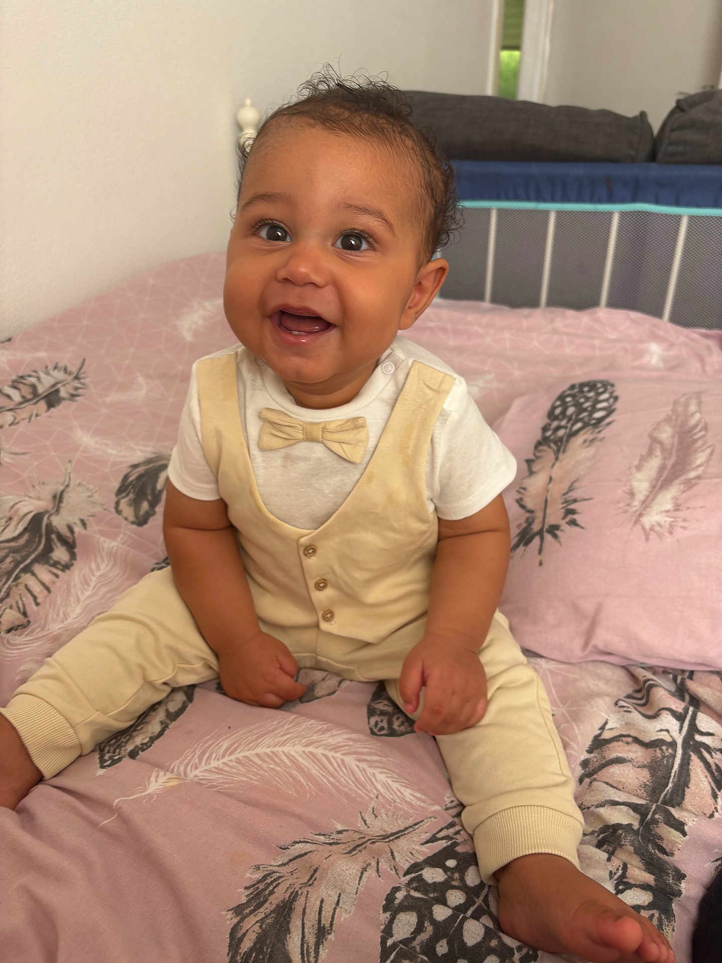 Saint Given joined the competition — help win amazing prizes! baby, bed, blanket, bow_tie, child, clothing, cream_outfit, cute, feather_pattern, furniture, happy, home, indoors, infant, person, pink, portrait, sitting, smiling, young_child