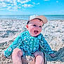baby, child, beach, sand, ocean, sky, blue_sky, cap, smiling, happy, sunny, vacation, summer, sitting, swimsuit, floral_pattern, outdoor, water, nature, portrait