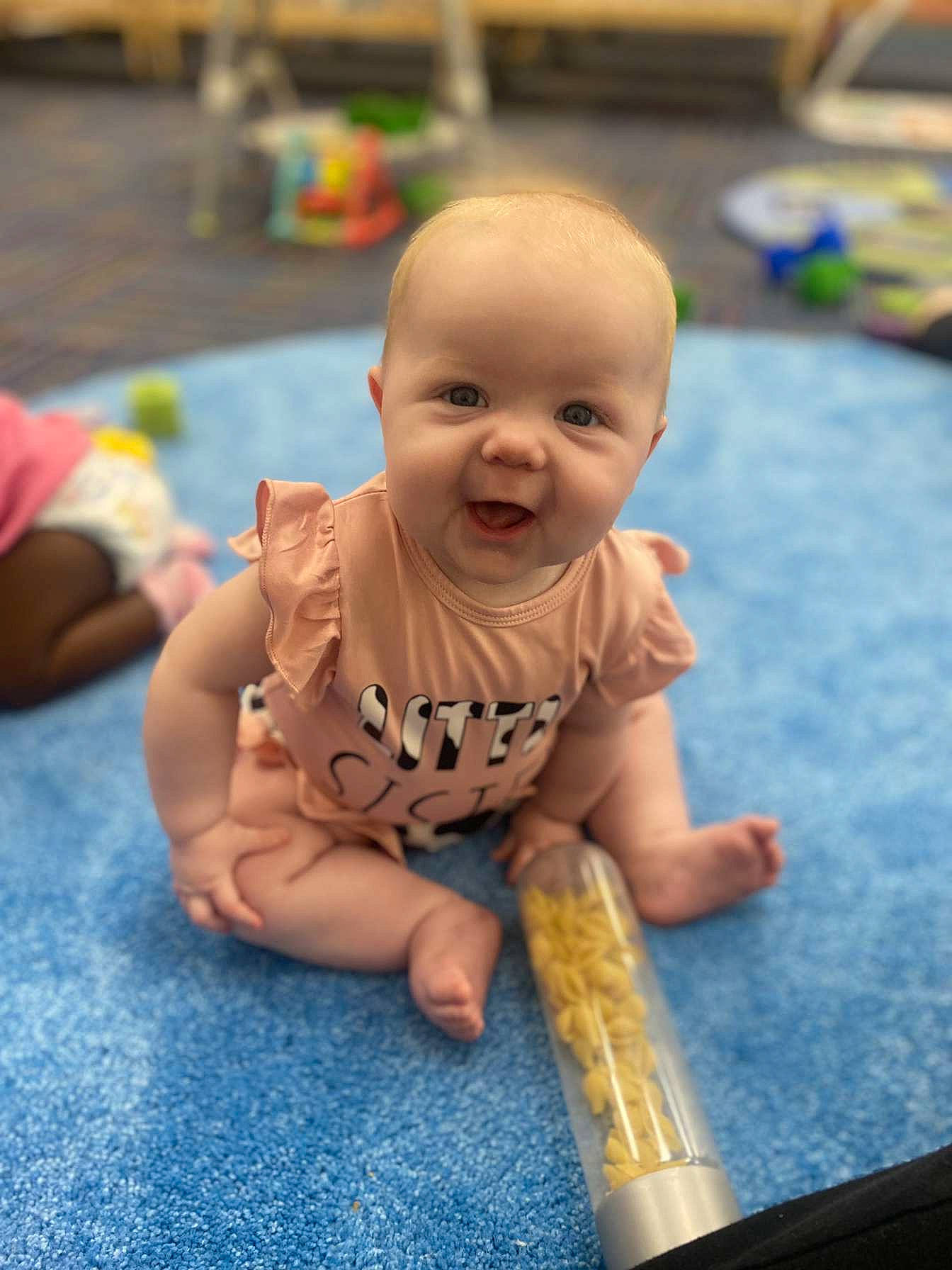 Aileen joined the competition — help win amazing prizes! baby, baseball_bat, cheek, child, flooring, fun, happy, joy, leisure, musical_instrument, person, photograph, play, recreation, room, sitting, smile, snapshot, toddler, vacation