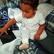 Fasha Douglas joined the competition — help win amazing prizes! baby, bed, blanket, child, comfort, cozy, curious, footwear, furniture, home, indoor, pajamas, person, plaid, remote_control, sitting, sleepwear, soft, toddler, young_child