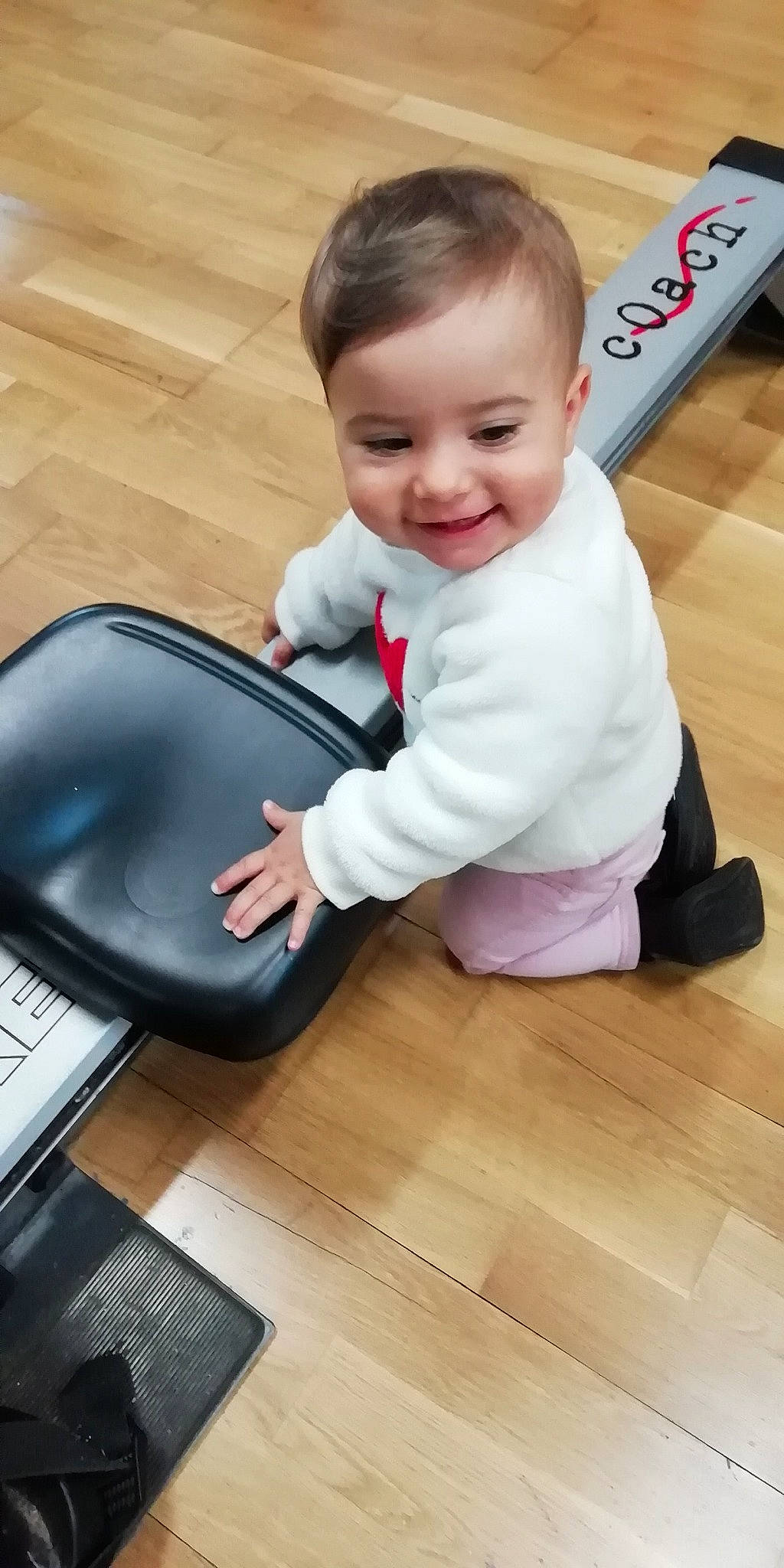 Melina a rejoint le concours — aidez-le/la à gagner de superbes lots ! baby, baby_products, baby_toddler_clothing, child, comfort, floor, flooring, fun, hair, happy, hardwood, joy, leisure, person, shoe, sitting, skin, smile, sneakers, table