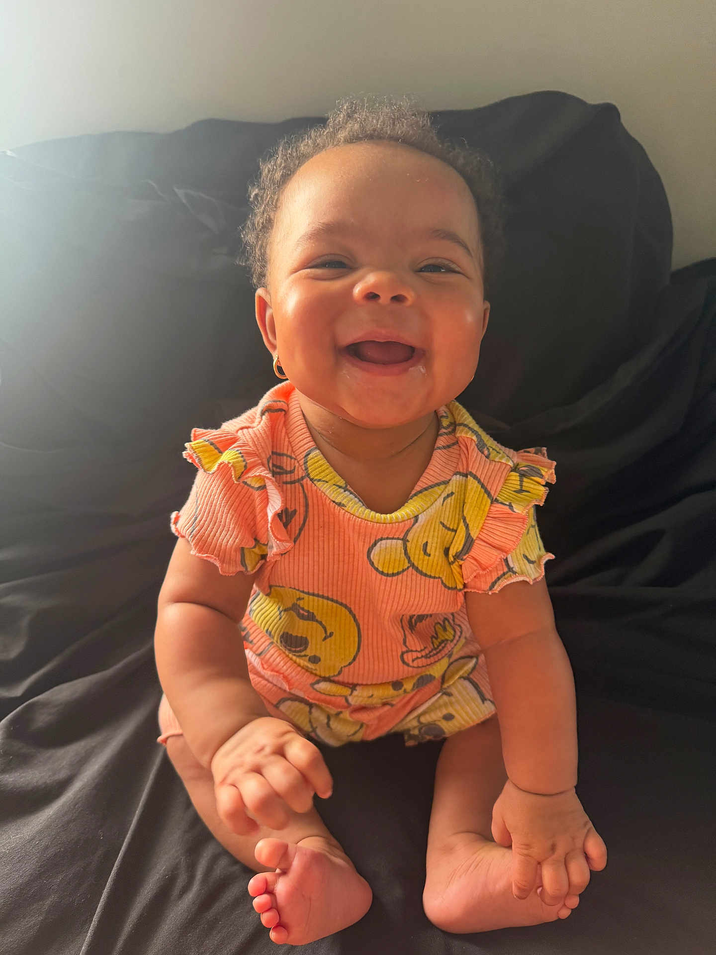 Kalani joined the competition — help win amazing prizes! baby, child, smiling, sitting, curly_hair, earring, colorful_clothing, patterned_outfit, happy, indoor, skin, face, hands, feet, infant, portrait, cute, young, person, bright