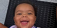 Kalani is registered to the contest to win money with this photo: baby, smiling, child, bib, minnie_mouse, polka_dot, shirt, earrings, happy, face, portrait, seated, indoor, texture, wall, chair, infant, cute, person, joyful