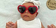 Kalani is registered to the contest to win money with this photo: accessory, adorable, baby, baby_fashion, blanket, bow, child, cute, fashion, five_months, headband, heart_shaped, indoor, infant, laying_down, person, portrait, soft_texture, sunglasses, white_dress