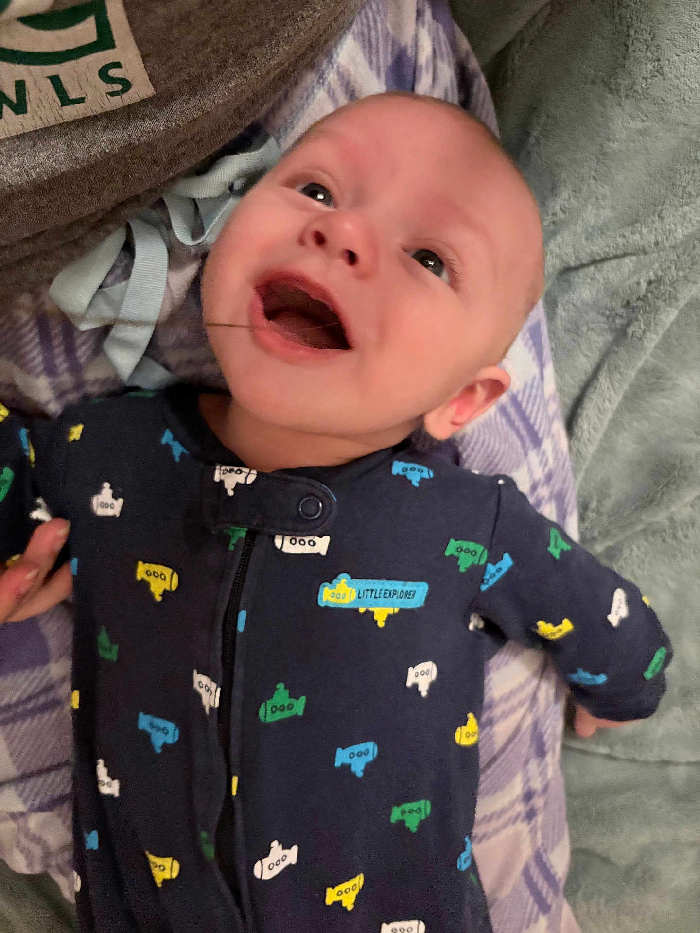 Jeremiah joined the competition — help win amazing prizes! baby, infant, smiling, sleepwear, submarine_pattern, plaid_blanket, lying_down, happy, child, portrait, indoor, blue, colorful, soft_texture, cute, young, one_person, face, apparel, cozy