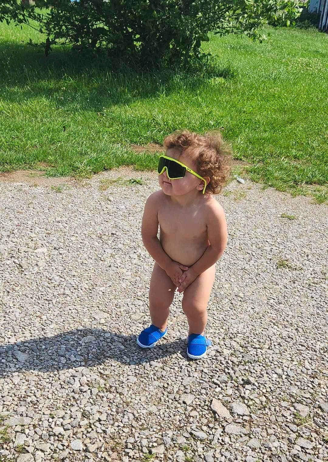 Jake is registered to the contest to win money with this photo: asphalt, barechested, chest, electric_blue, eyewear, fun, glasses, goggles, grass, human_leg, leisure, people_in_nature, person, plant, recreation, sunglasses, swimwear, thigh, toddler, trunk