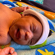 Jahari joined the competition — help win amazing prizes! baby, newborn, smiling, face, headwear, blanket, colorful, skin, hand, peaceful, infant, lying, closeup, cozy, child, cute, sleepy, soft, warm, adorable