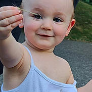Elizabeth participe au concours pour gagner de l'argent avec cette photo : arm, casual_clothing, child, curly_hair, cute, eyes, face, grass, hand, happy, nature, outdoor, pavement, person, playful, skin, smile, toddler, white_tank_top, young_child