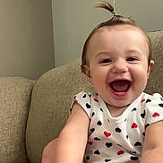 Madison joined the competition — help win amazing prizes! baby, child, smiling, happy, indoor, couch, clothing, person, face, foot, hand, hair, ponytail, pattern, hearts, infant, cute, joyful, sitting, skin