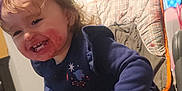 Atalli is registered to the contest to win money with this photo: berry_juice, child, clothing, curtains, cute, food, furniture, hair, hand, happy, high_chair, indoor, kitchen, long_sleeve, messy_face, person, seat, smiling, snack_time, toddler