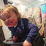 Atalli is registered to the contest to win money with this photo: toddler, child, high_chair, smiling, messy_face, berry_juice, snack_time, indoor, kitchen, curtains, clothing, long_sleeve, hair, happy, food, hand, seat, furniture, person, cute