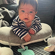 Zayne is registered to the contest to win money with this photo: baby, infant, striped_clothing, pillow, soft_toy, blanket, indoor, curious, face, hands, couch, child, young, cute, portrait, closeup, home, comfort, teething_toy, expression