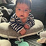 baby, infant, striped_clothing, pillow, soft_toy, blanket, indoor, curious, face, hands, couch, child, young, cute, portrait, closeup, home, comfort, teething_toy, expression