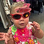Leia joined the competition — help win amazing prizes! toddler, child, sunglasses, red_sunglasses, dress, floral_dress, indoor, carpet, clothing_rack, hand, face, person, cute, baby, fashion, toy_brand_tag, playful, colorful, apparel, young_child