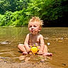 toddler, child, water, river, nature, outdoor, summer, sunny, hair, spiky_hair, greenery, forest, sand, reflection, barefoot, cute, sitting, playful, emoji, sun