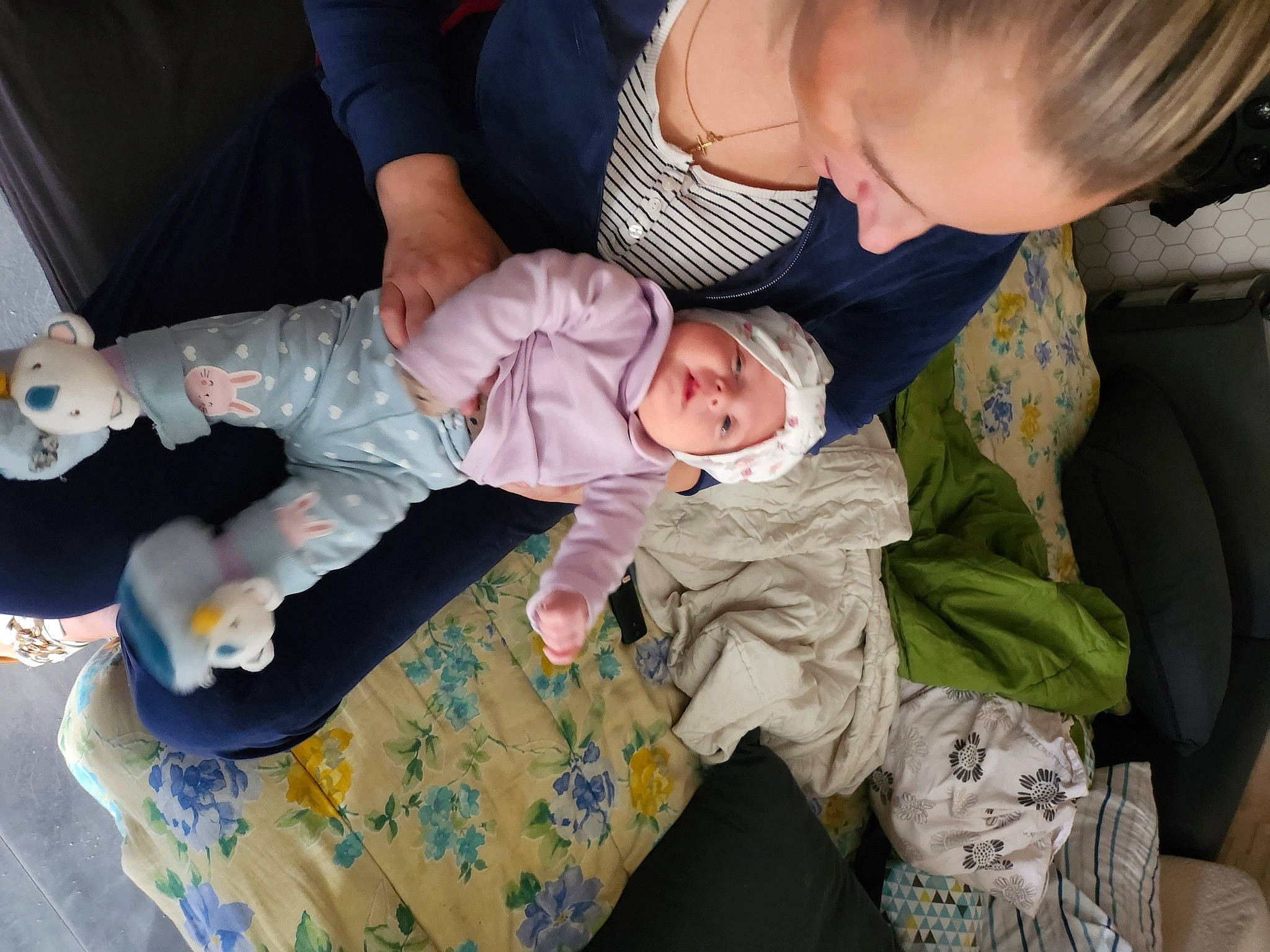 Mila participe au concours pour gagner de l'argent avec cette photo : baby, baby_products, baby_toddler_clothing, camouflage, child, comfort, flooring, foot, fun, head, headwear, lap, military_camouflage, pattern, person, room, sitting, sock, toddler, tree