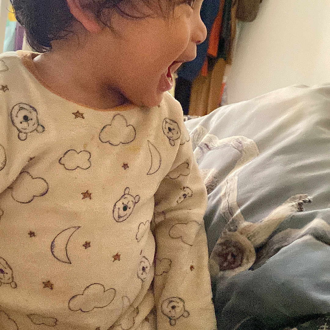 Amaru a rejoint le concours — aidez-le/la à gagner de superbes lots ! bedroom, blanket, casual, child, clothing, cozy, cute, expression, face, furniture, hair, happy, home, indoors, laughing, pajamas, person, profile, smiling, toddler