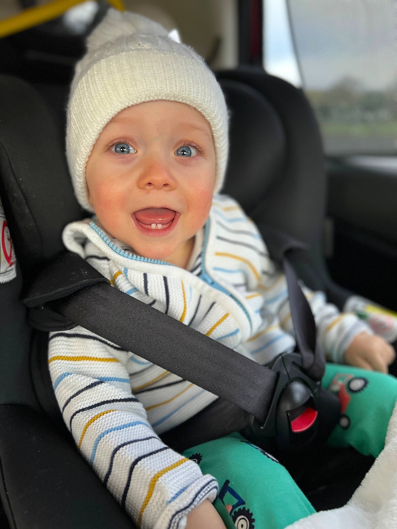 Devon is registered to the contest to win money with this photo: auto_part, automotive_design, baby, baby_carriage, baby_in_car_seat, baby_products, car, car_seat, car_seat_cover, comfort, electric_blue, happy, head_restraint, headwear, motor_vehicle, person, seat_belt, smile, steering_part, steering_wheel