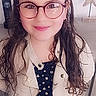 accessory, casual, child, curly_hair, decor, face, fashion, floral_top, girl, glasses, hair, happy, indoor, jacket, long_hair, person, portrait, smiling, standing, young