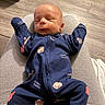 Paxtyn joined the competition — help win amazing prizes! baby, newborn, sleeping, onesie, clothing, person, lap, floor, wood_flooring, indoor, cozy, child, infant, cute, patterned_clothing, relaxed, small_person, soft_lighting, casual, peaceful