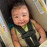 baby, car_seat, child, smile, face, straps, clothing, infant, seatbelt, cute, person, indoors, sitting, hair, skin, hand, shoulder, warning_label, pacifier, secure