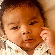 Ayden is registered to the contest to win money with this photo: baby, infant, face, portrait, closeup, child, person, expression, hand, skin, hair, eyebrows, eyes, clothing, button, texture, indoors, cute, thoughtful, young