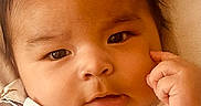 Ayden is registered to the contest to win money with this photo: baby, button, child, closeup, clothing, cute, expression, eyebrows, eyes, face, hair, hand, indoors, infant, person, portrait, skin, texture, thoughtful, young