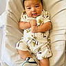 Ayden is registered to the contest to win money with this photo: baby, infant, child, clothing, tropical, palm_trees, white_blanket, soft_texture, cute, portrait, indoors, relaxed, footwear, sneakers, sleepwear, hands, face, skin, expression, lying_down
