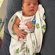 Maëlan participe au concours pour gagner de l'argent avec cette photo : newborn, baby, sleeping, blanket, turtle_pattern, hospital_wristband, white_clothing, infant, wrapped, soft_texture, gray_background, peaceful, cute, resting, child, portrait, indoors, skin, hand, face