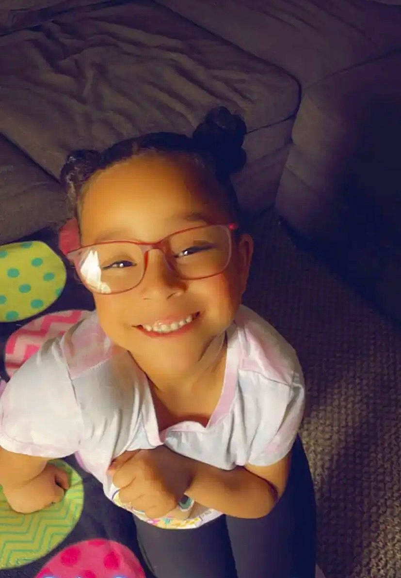 Lyrik is registered to the contest to win money with this photo: chest, child, eyewear, finger, fun, gesture, glasses, happy, joy, leisure, lip, mouth, nose, person, play, sitting, skin, smile, thumb, toddler