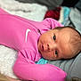 baby, newborn, infant, pink_onesie, nike_logo, blanket, soft_texture, lying_down, close_up, face, eyes, curious, indoors, sleepwear, baby_clothing, portrait, head, skin, young_child, cute