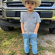 Abel joined the competition — help win amazing prizes! child, boy, cowboy_hat, jeans, tshirt, boots, necklace, cross, truck, ford, outdoor, grass, dirt, vehicle, portrait, standing, casual_clothing, young_child, hands_in_pockets, daytime