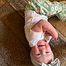 baby, infant, smiling, upside_down, headband, bow, white_shirt, green_pants, floral_pattern, carpet, floor, happy, cute, child, indoors, playful, skin, face, person, toddler