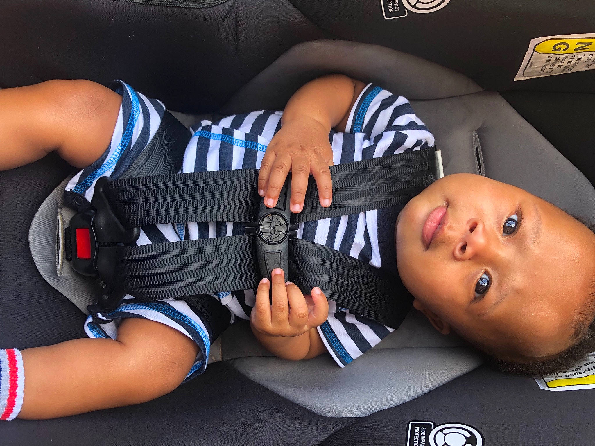 Iyon is registered to the contest to win money with this photo: baby, baby_in_car_seat, baby_toddler_clothing, car_seat, comfort, elbow, finger, gesture, human_body, human_leg, joint, knee, leg, nail, person, product, sleeve, sock, thigh, thumb