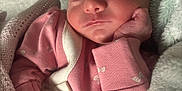 Gracie is registered to the contest to win money with this photo: newborn, baby, sleeping, pink_clothing, blanket, infant, peaceful, hand, face, soft_texture, cozy, cute, indoors, portrait, closeup, child, young, wrapped, resting, toddler