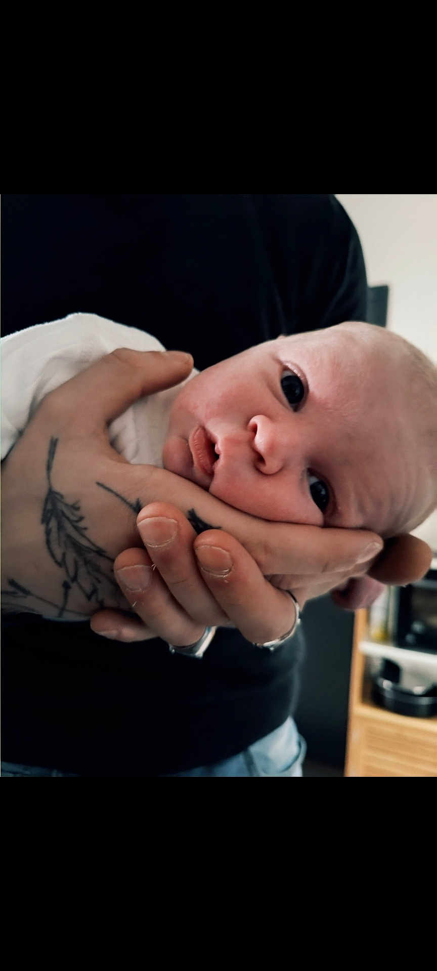 Théo participe au concours pour gagner de l'argent avec cette photo : baby, infant, hand, tattoo, skin, face, eyes, person, newborn, adult, contrast, closeup, portrait, gentle, holding, fingers, expression, indoor, soft_light, human