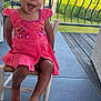 toddler, child, smiling, pink_dress, chair, porch, outdoor, greenery, railing, barefoot, happy, person, young_child, summer, daylight, smile, cute, playful, sitting, garden