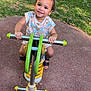 toddler, child, playground, spring_rocker, green, yellow, smiling, happy, outdoor, grass, pavement, summer, play, fun, cute, person, footwear, patterned_clothing, baby, park
