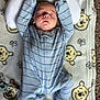 baby, infant, sleeping, onesie, blue_stripes, blanket, winnie_the_pooh, cartoon_faces, bear_pillow, carpet, soft_texture, child, cute, peaceful, indoors, floor, comfort, resting, toddler, pacifier
