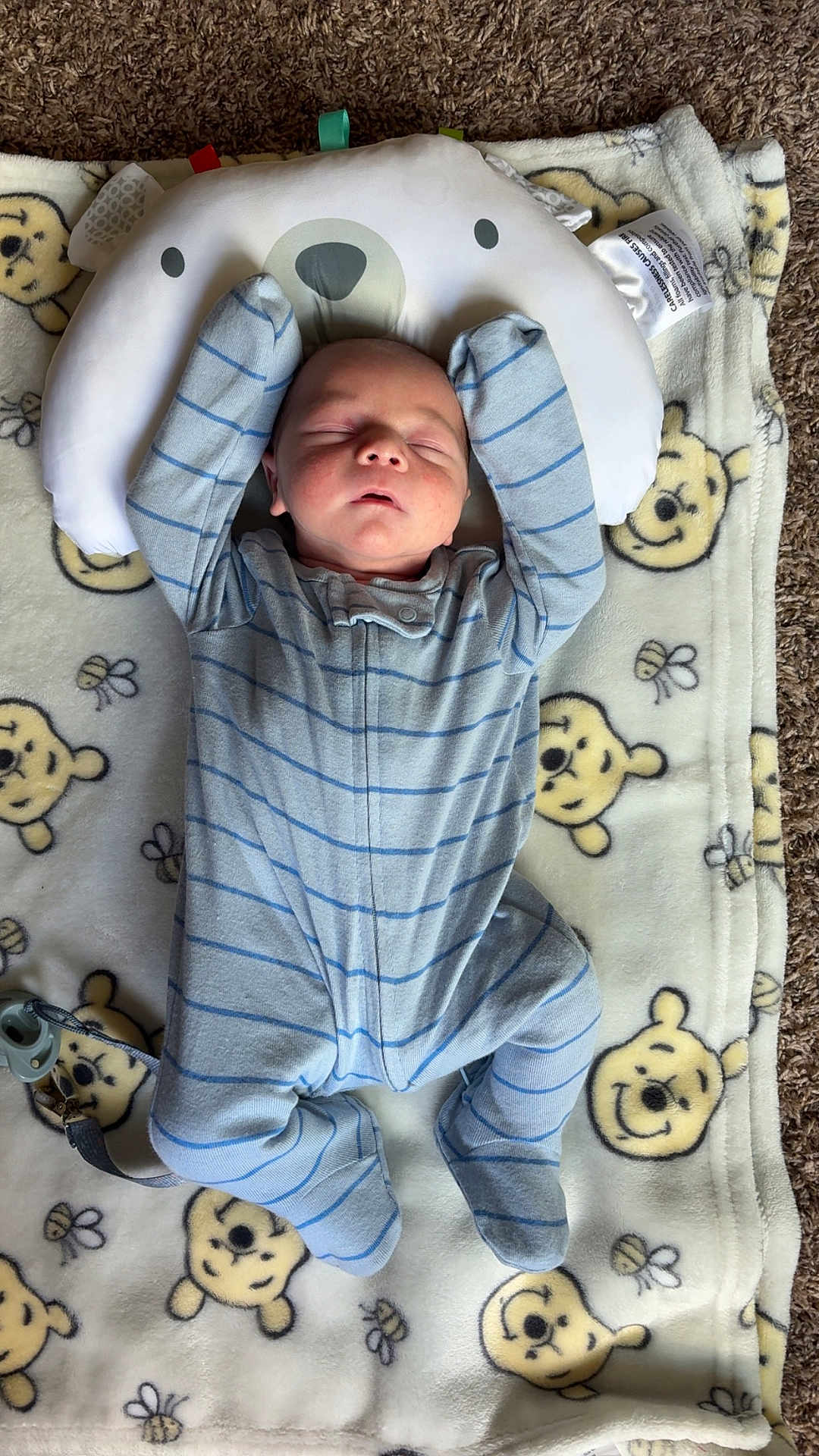 Levi joined the competition — help win amazing prizes! baby, infant, sleeping, onesie, blue_stripes, blanket, winnie_the_pooh, cartoon_faces, bear_pillow, carpet, soft_texture, child, cute, peaceful, indoors, floor, comfort, resting, toddler, pacifier